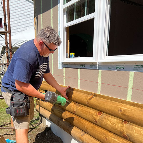 General Contractor Kevin Tarkovich installs exterior siding on the Tionesta getaway cabin.