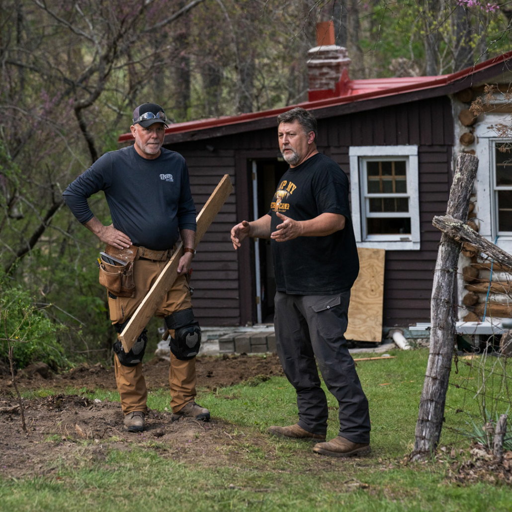Renovation Hunters team discussing log home restoration.