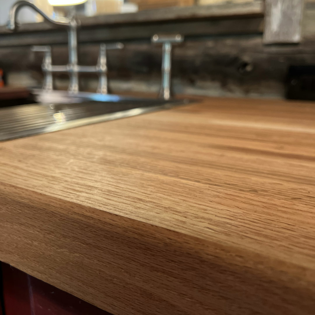 Close-up of the hardwood kitchen counter in Renovation Hunters’ log cabin restoration.